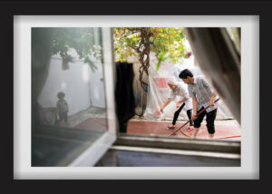 Bahram and Hanieh are washing their old carpet in Bahram’s father’s yard. Their daughter, Baran, can be seen in the reflection in the window on the left corner of the picture. Hanieh, several months ago, left Bahram because she felt that they were not independent at Bahram's father's house. She went to her father's house in a village in Zanjan. She has returned, and Bahram has promised her to rent out a place for themselves. 18.08.2017