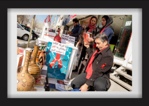Mohammadreza and Behnaz are in front of Haghighate Narenj Office on World AIDS Day (December 1st) trying to spread awareness about this issue to reduce the damage it does to society. Behnaz is talking to a woman about this disease. The United Nation’s Motto is “Living with HIV without stigma”. Every club sets stands to inform people. Mohammadreza is of the opinion that because Karaj is a city of immigrants, it has great potential in the reducing of social harms. 11.12.2014